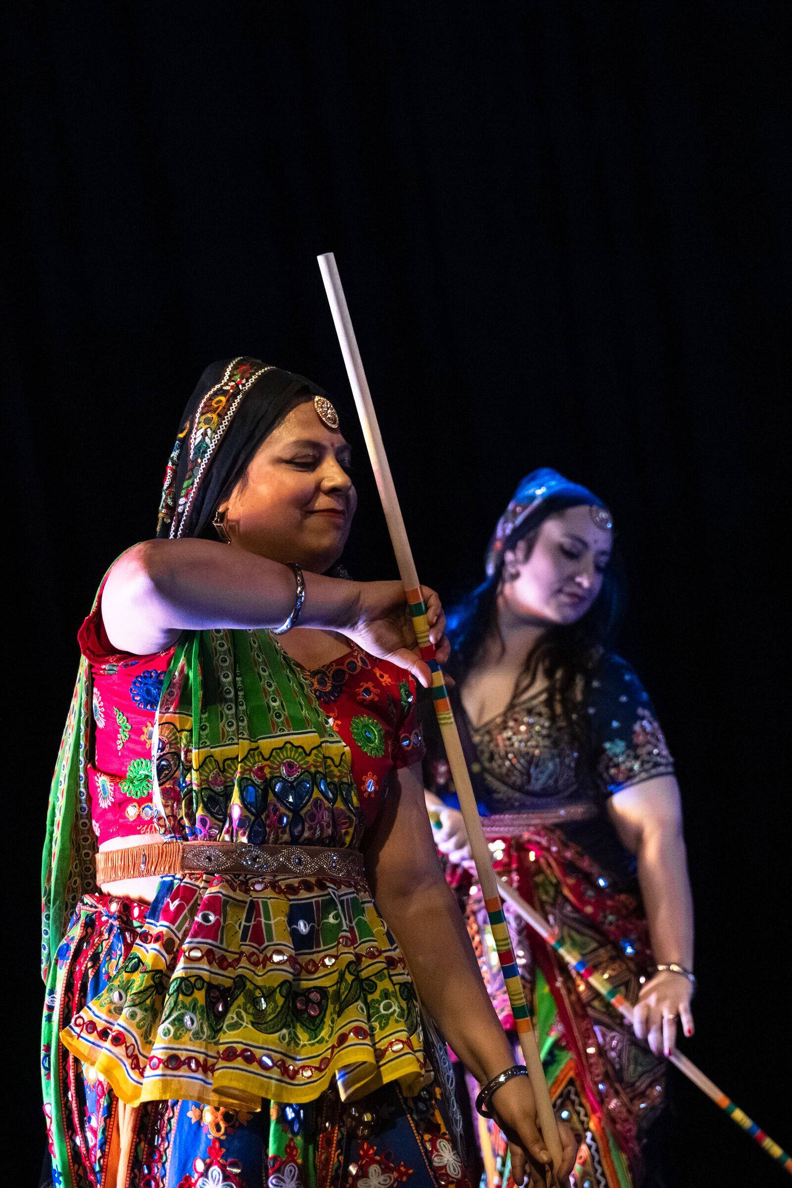 A Bollyfolk dancer mid-move with a tippani stick raised.